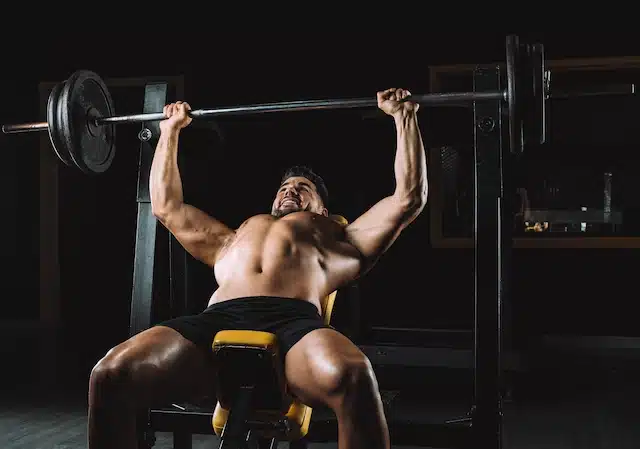 Muscular man doing an incline bench press