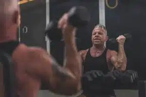 Man performing a seated Arnold Press with heavy dumbbells