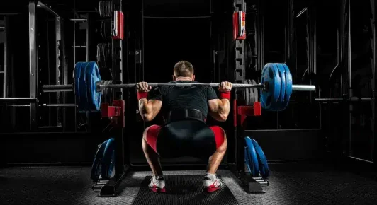 Man back squatting for a powerlifting competition